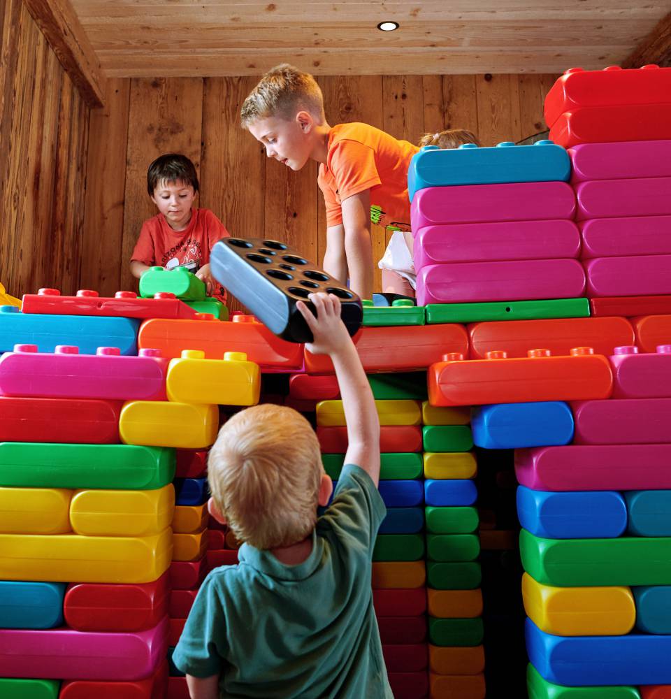 Kinder bauen ein Haus mit riesigen Klemmbausteinen